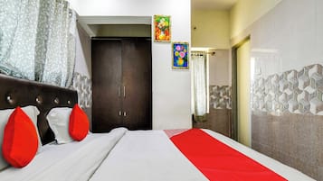 Una habitación de hotel con una cama, un armario y un baño visible a través de una puerta abierta.