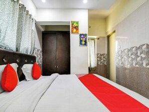 A hotel room with a bed, a wardrobe, and a bathroom visible through an open door. - Hotel O BR Greens (Indore)
