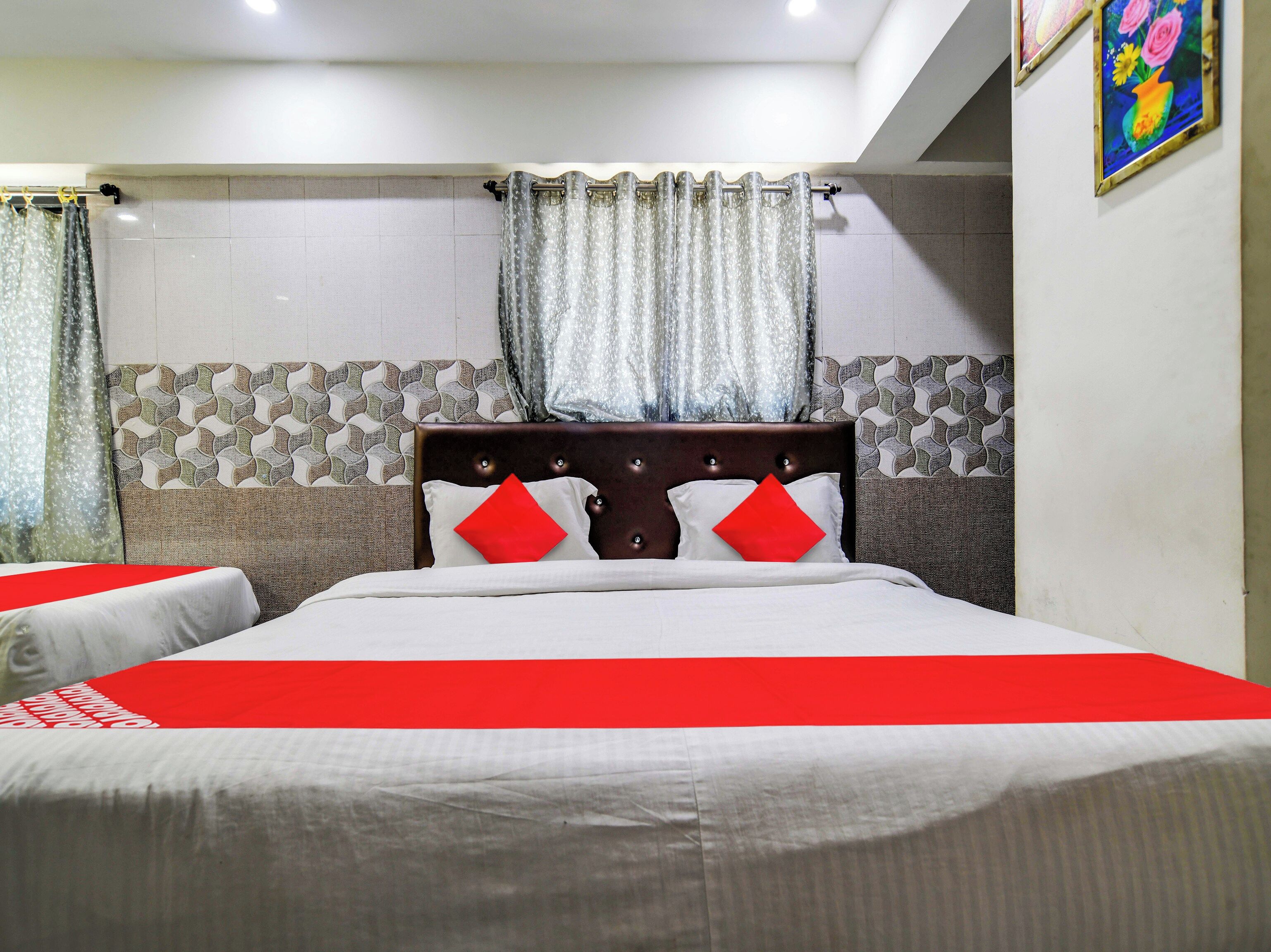 Una habitación de hotel con cama, cortinas y pared con diseño.