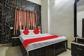 Une chambre à coucher comprenant un lit, des tables de chevet, une commode, un miroir et un mur orné d’un motif noir et doré.