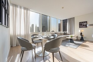 A modern living room with a dining area, large windows, and a city view. - High-Floor 2BR with City Views and Near Dubai's Major Landmarks, Sky Gardens (Dubai)