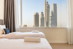 Ein Hotelzimmer mit großem Fenster und Blick auf hohe Gebäude.