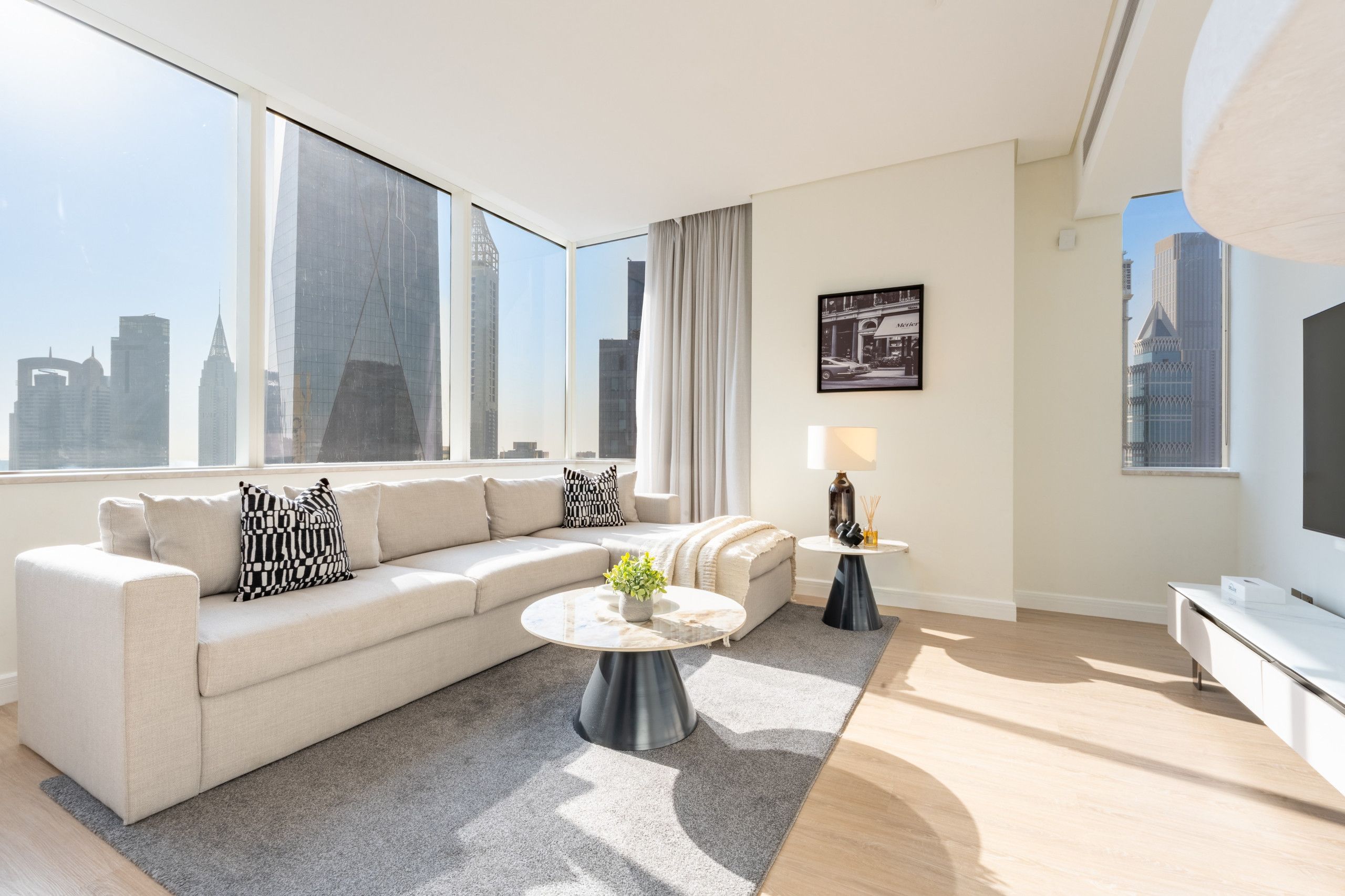 A modern living room with a sofa, a coffee table, and a view of the city skyline.