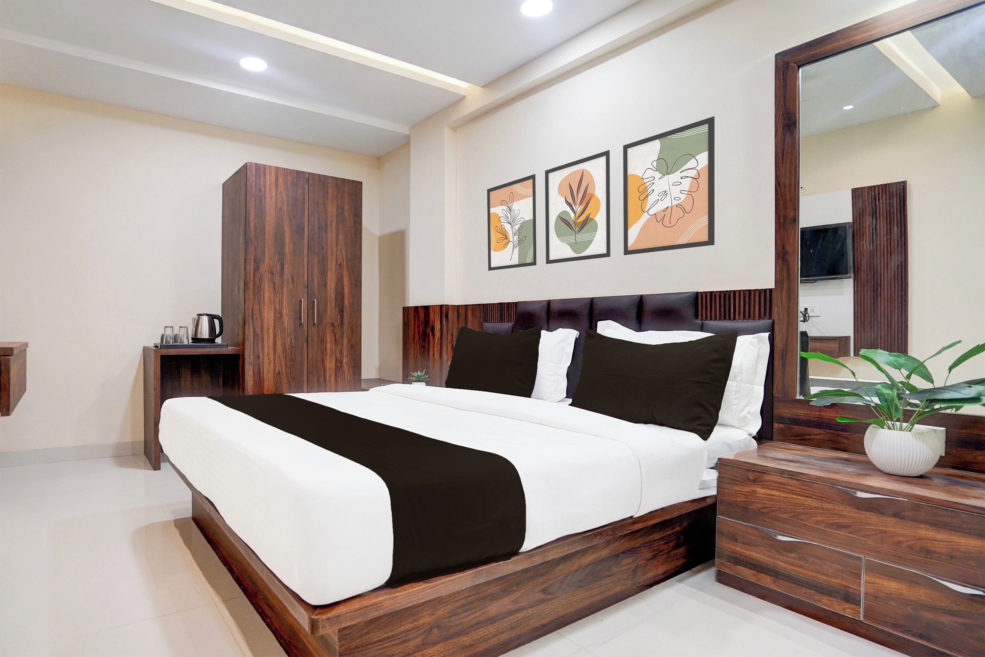 A modern bedroom with a large bed, wooden wardrobe, bedside tables, and a mirror.