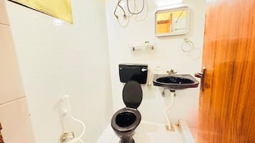 Un baño con inodoro, lavamanos y espejo.