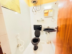 Een badkamer met toilet, wastafel en spiegel.
