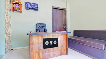 Bancada de recepção com acabamento em madeira e uma placa com a inscrição 'OYO'.