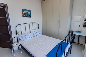 A bedroom with a bed, bedside table, lamp, wardrobe, and a desk with a chair. - Holiday Home 'Art Of Luxury Superior Villa' with Sea View, Private Terrace and Air Conditioning (Κάτω Πολυδένδρι)