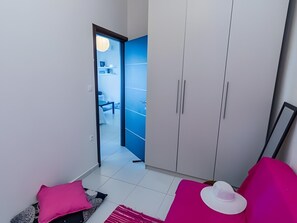 Una habitación moderna con un armario, una cama y vista a otra habitación.