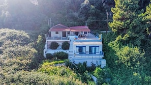 A two-story house with a red roof, surrounded by dense greenery. - Holiday Home 'Art Of Luxury' with Sea View, Private Terrace and Air Conditioning (Κάτω Πολυδένδρι)