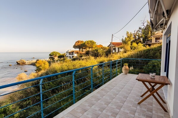 A balcony with a view of the sea and houses in the background. - Holiday Home 'Art Of Luxury' with Sea View, Private Terrace and Air Conditioning (Κάτω Πολυδένδρι)