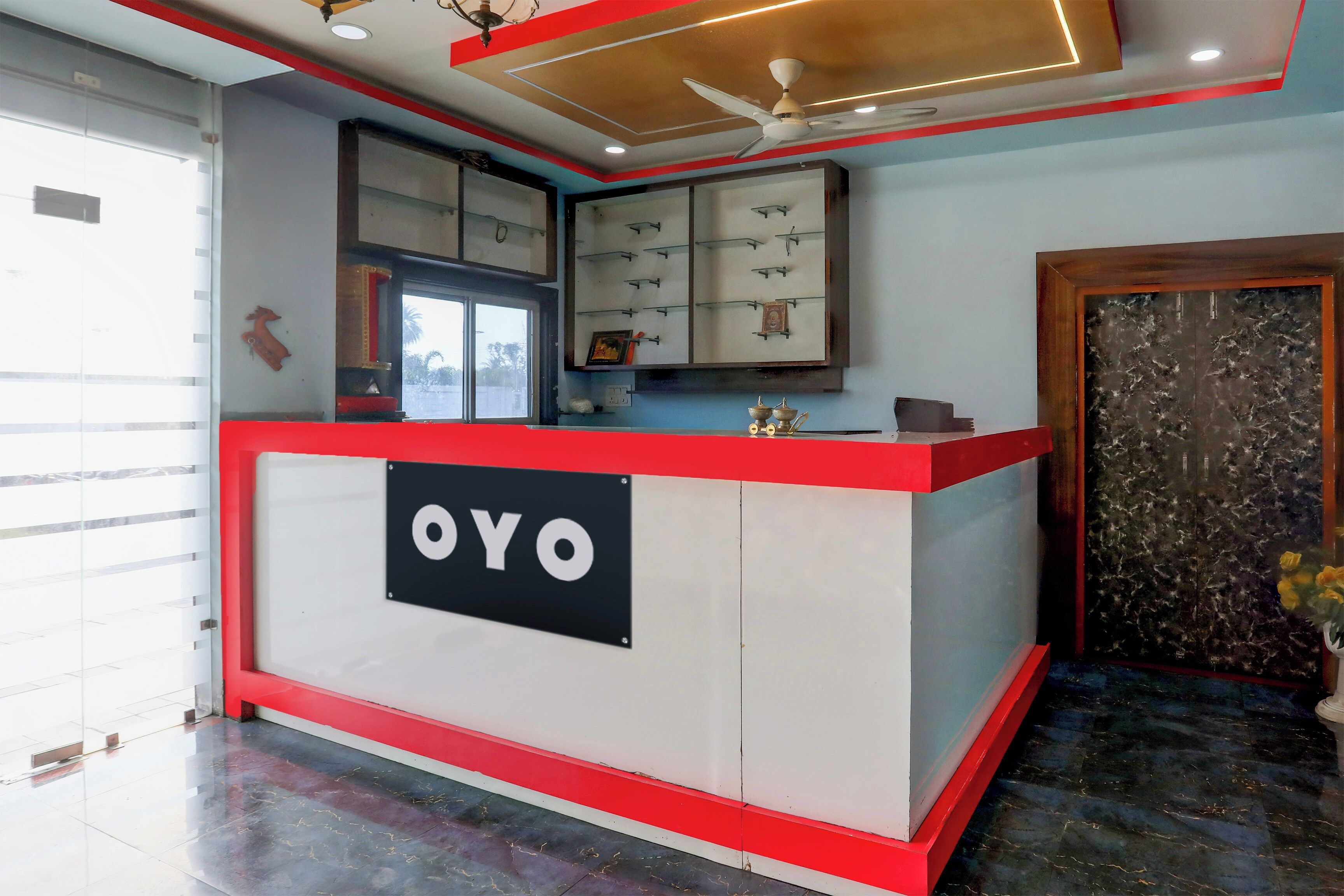 A reception desk with a sign reading 'OYO' in a modern hotel lobby.