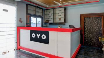 A reception desk with a sign reading 'OYO' in a modern hotel lobby.