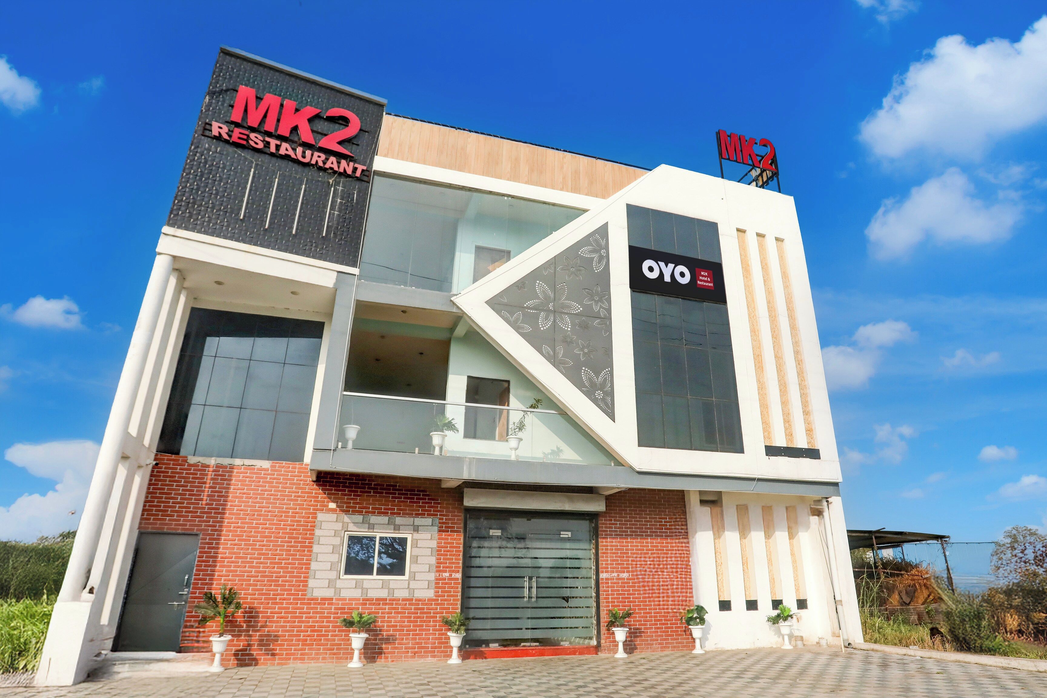 Um edifício moderno com destaque para o restaurante MK2, fachada de vidro e entrada visível.
