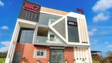 Um edifício moderno com destaque para o restaurante MK2, fachada de vidro e entrada visível.