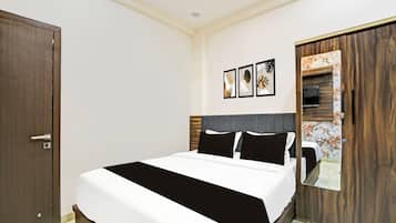 Un dormitorio con cama, armario y televisor montado en la pared.