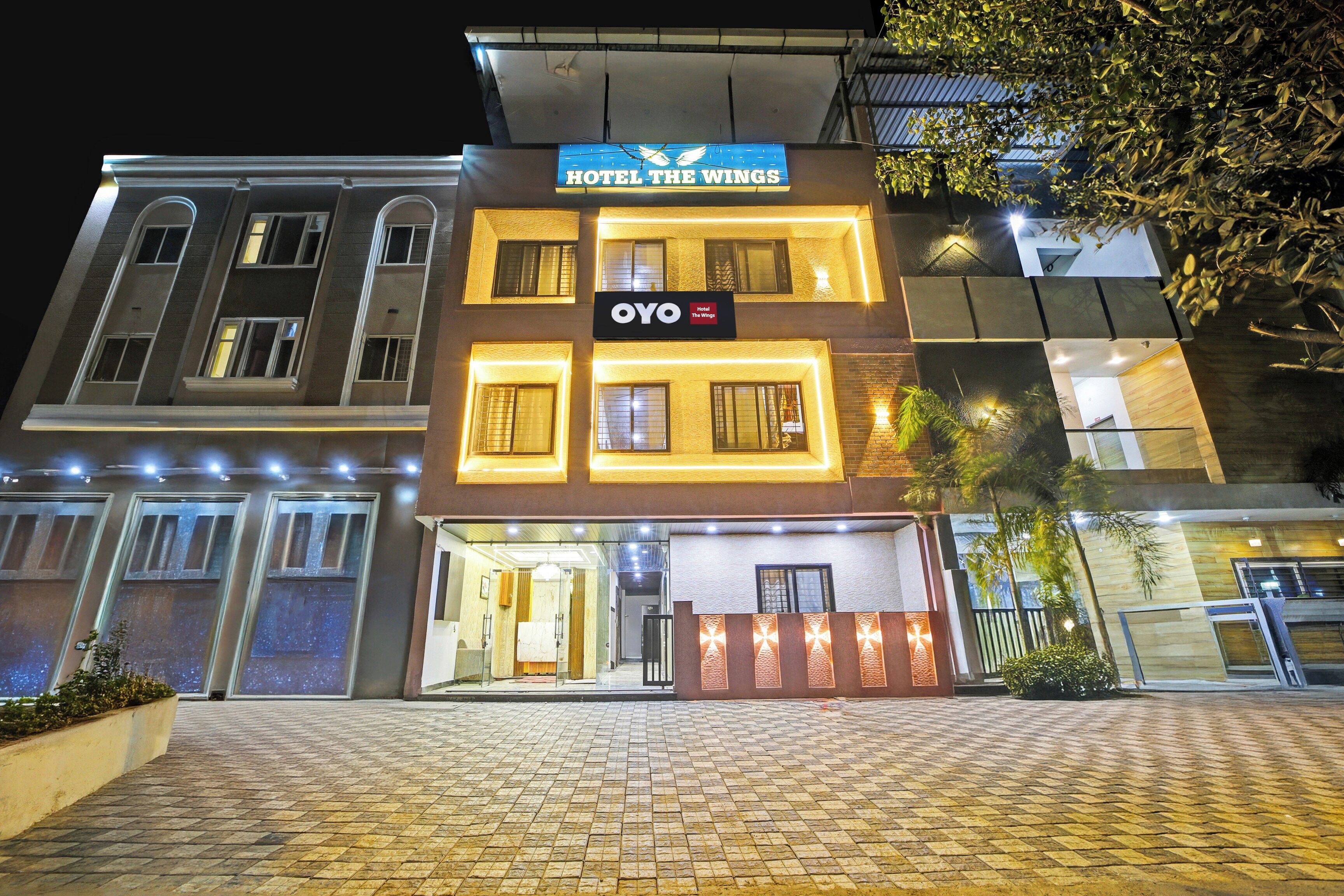 A hotel with a prominent sign reading 'HOTEL THE WINGS' and 'OYO Hotel The Wings' below.