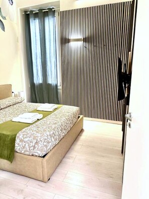 A bedroom with a bed, a window with curtains, a door, and a wall with vertical lines. - New Listing (Milano)