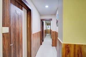 A hallway with a wooden door marked '01' and a white wall with a picture. - Hotel O Hotel Krishna's Residency (Indore)