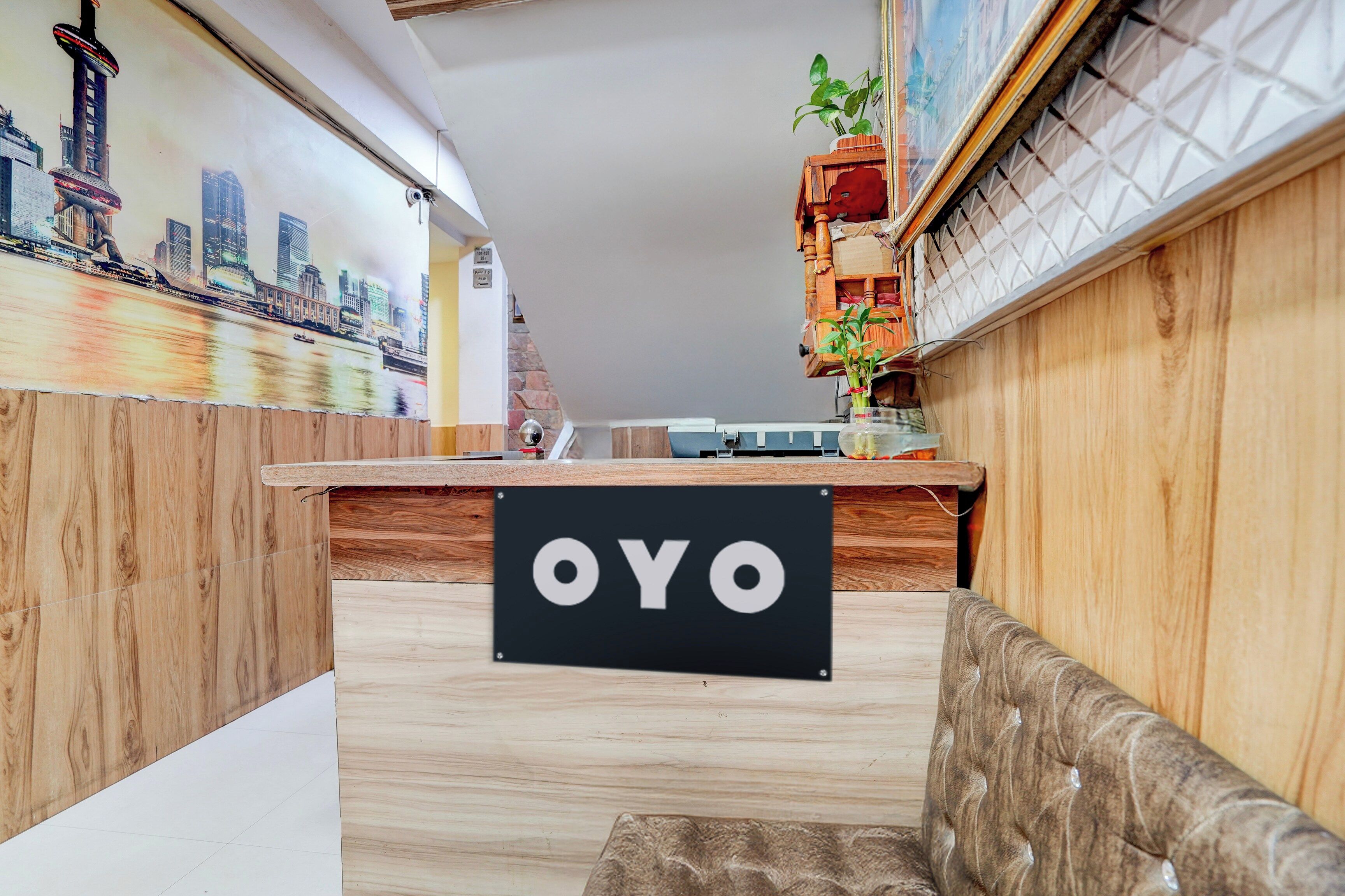Balcão de recepção com uma placa que diz 'OYO' no saguão de um hotel.