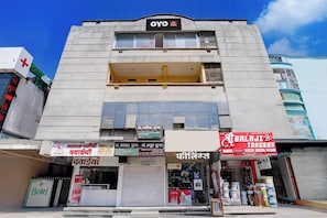 A hotel named 'OYO' with multiple shops on the ground floor, including a pharmacy and a trading store. - Hotel O Hotel Krishna's Residency (Indore)