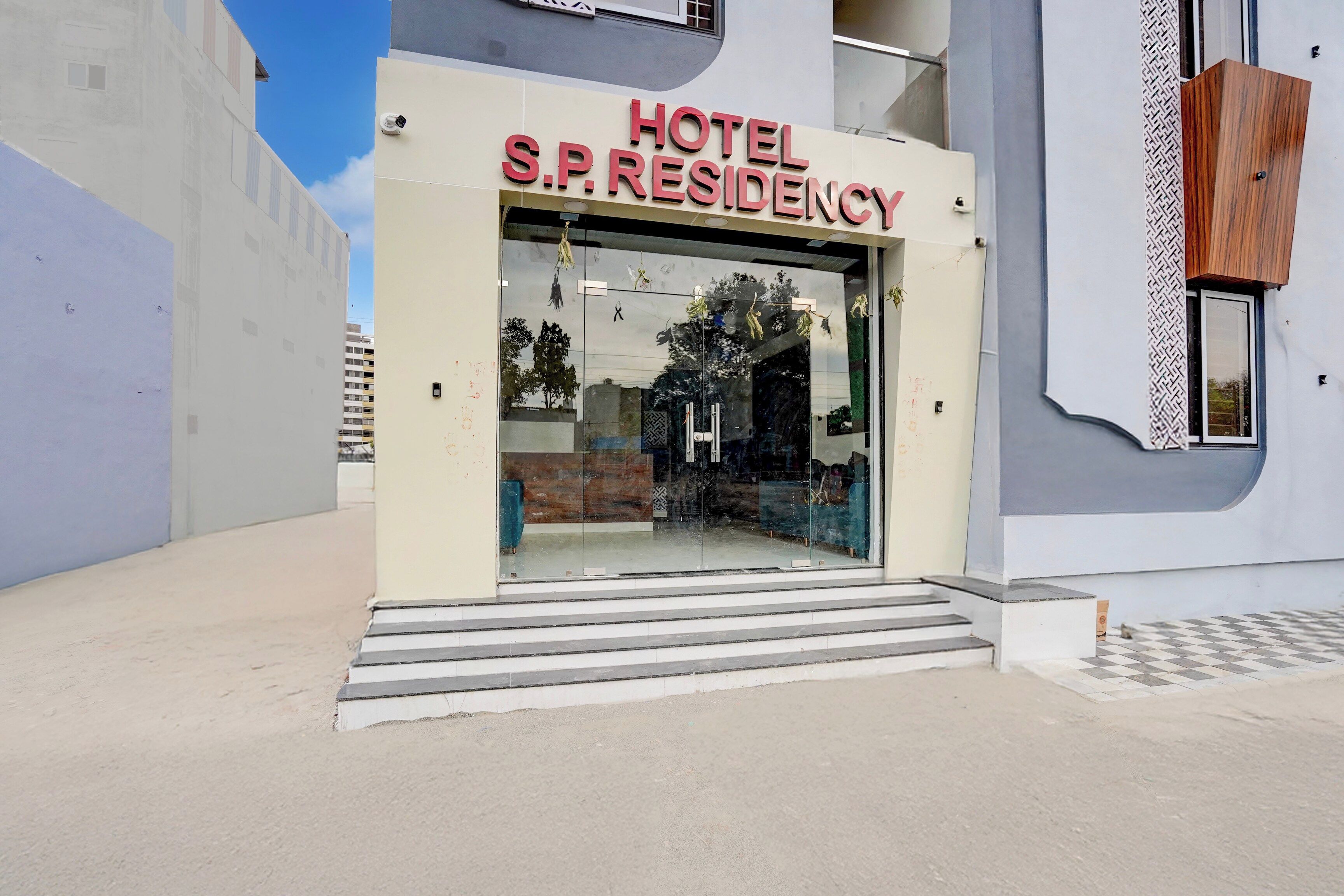 Entrada de hotel com uma placa indicando 'HOTEL S.P. RESIDENCY'.