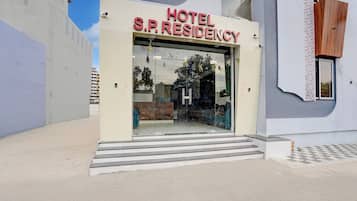 Entrada de hotel com uma placa indicando 'HOTEL S.P. RESIDENCY'.
