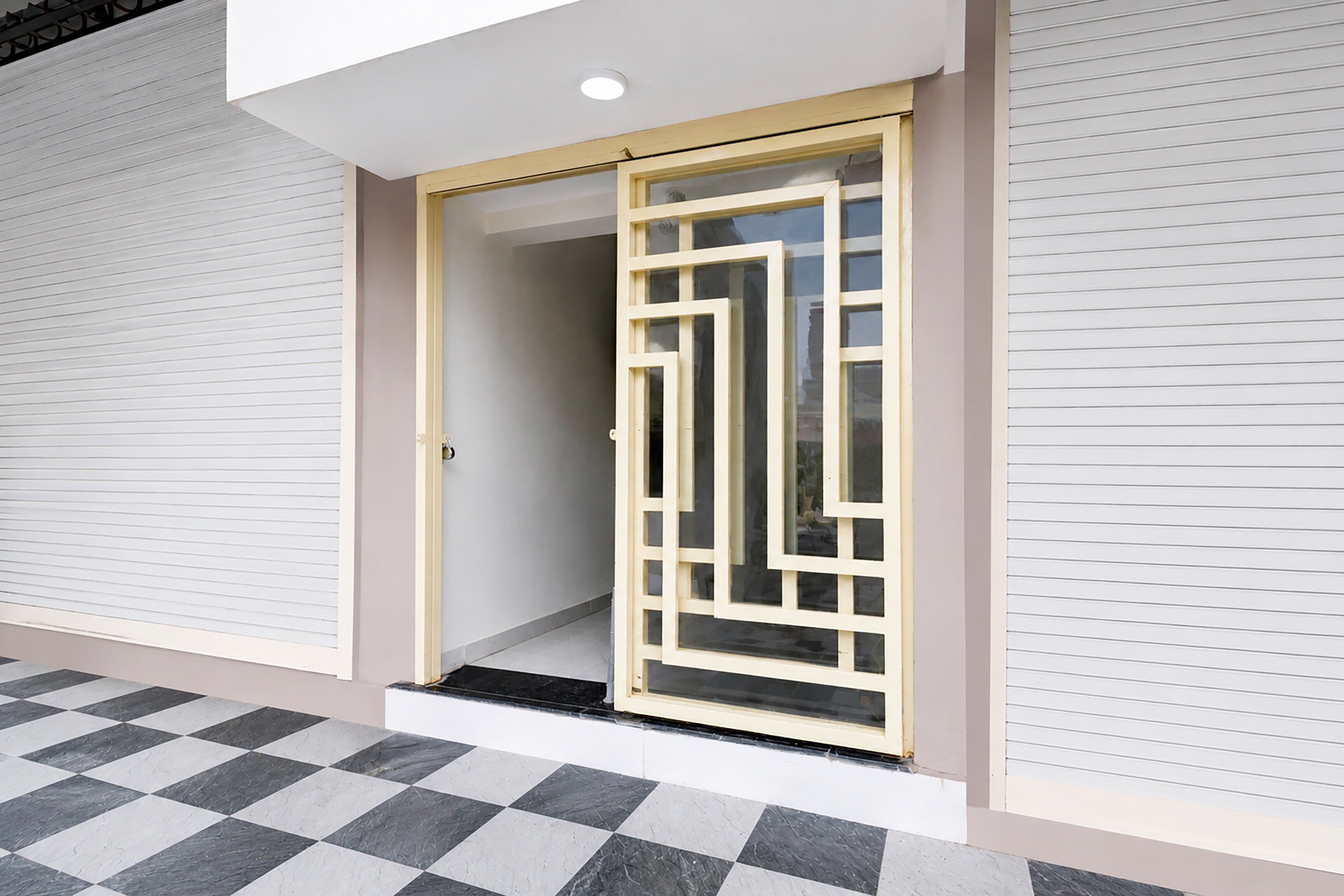 A modern building entrance with a glass door and a checkered floor pattern.
