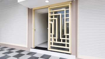 A modern building entrance with a glass door and a checkered floor pattern.