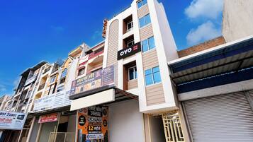 A multi-story building with various commercial establishments on the ground floor, including a hotel and a clinic.