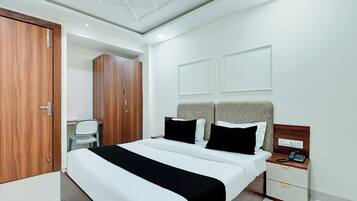 A modern bedroom with a large bed, bedside tables, a wardrobe, and a chair.