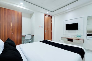 A hotel room with a bed, a desk, a chair, a TV, and a wardrobe. - Hotel O Balaji (Indore)