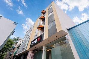 A modern hotel building with a prominent 'OYO' sign, multiple floors, and a clear sky in the background. - HOTEL O T9T (Indore)