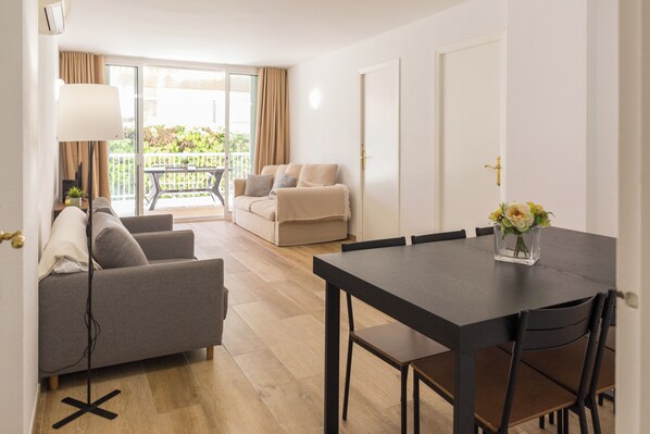 Ein Hotelzimmer mit Essbereich, einer Couch, einem Tisch und Blick ins Freie.