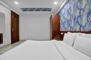 Une chambre à coucher avec un grand lit, une armoire en bois et un mur décoré de motifs.