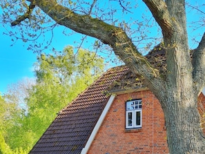 Ein Gebäude aus Ziegelsteinen mit schrägem Dach und einem Fenster.