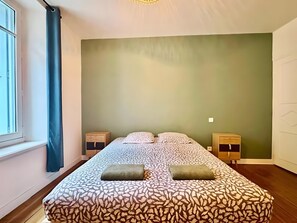 A bedroom with a bed, two bedside tables, a window with curtains, and a green wall. - Holiday Home 'Maison Jebari' (Carcassonne)