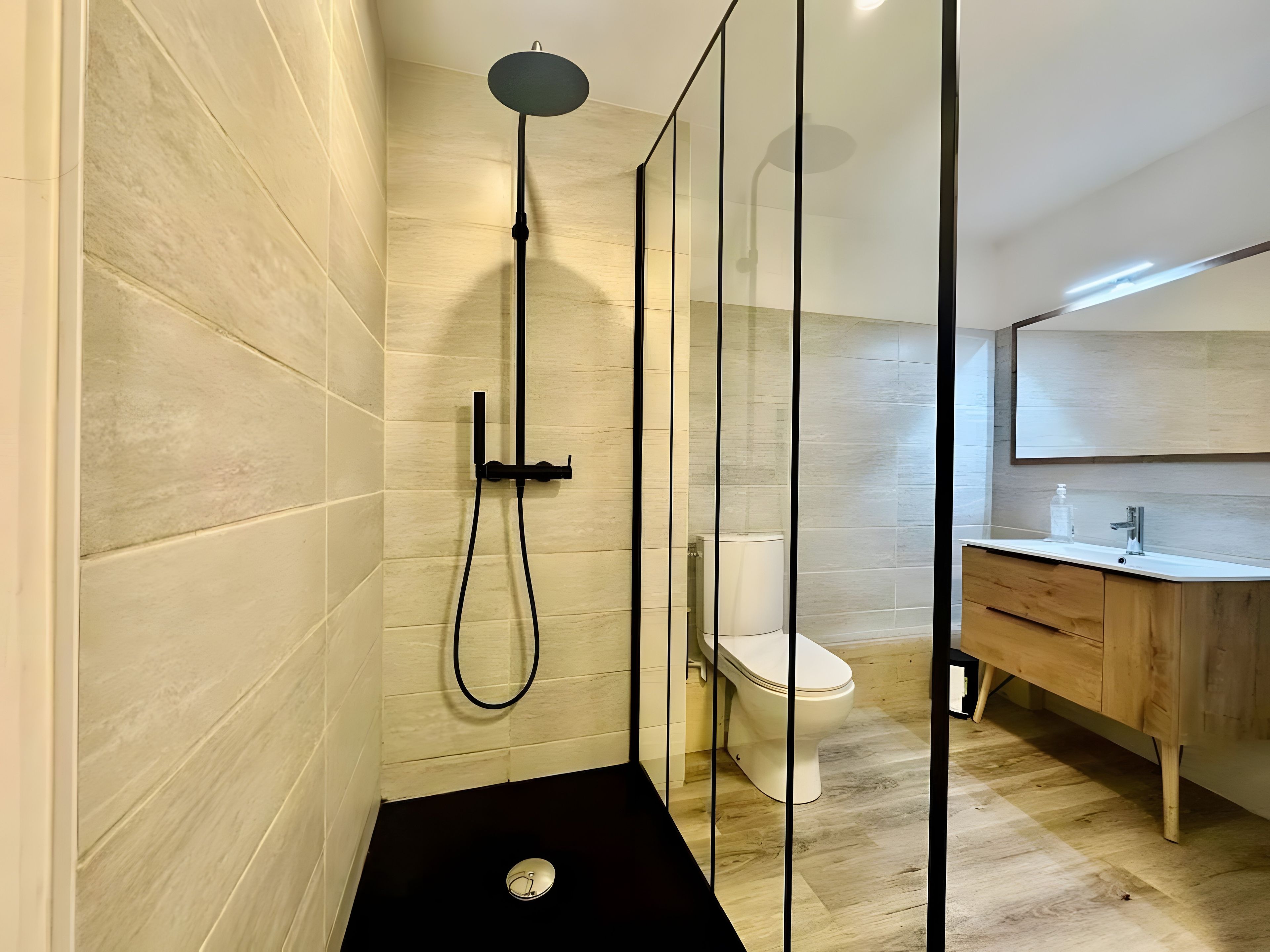 Un bagno moderno con doccia, WC e lavabo.