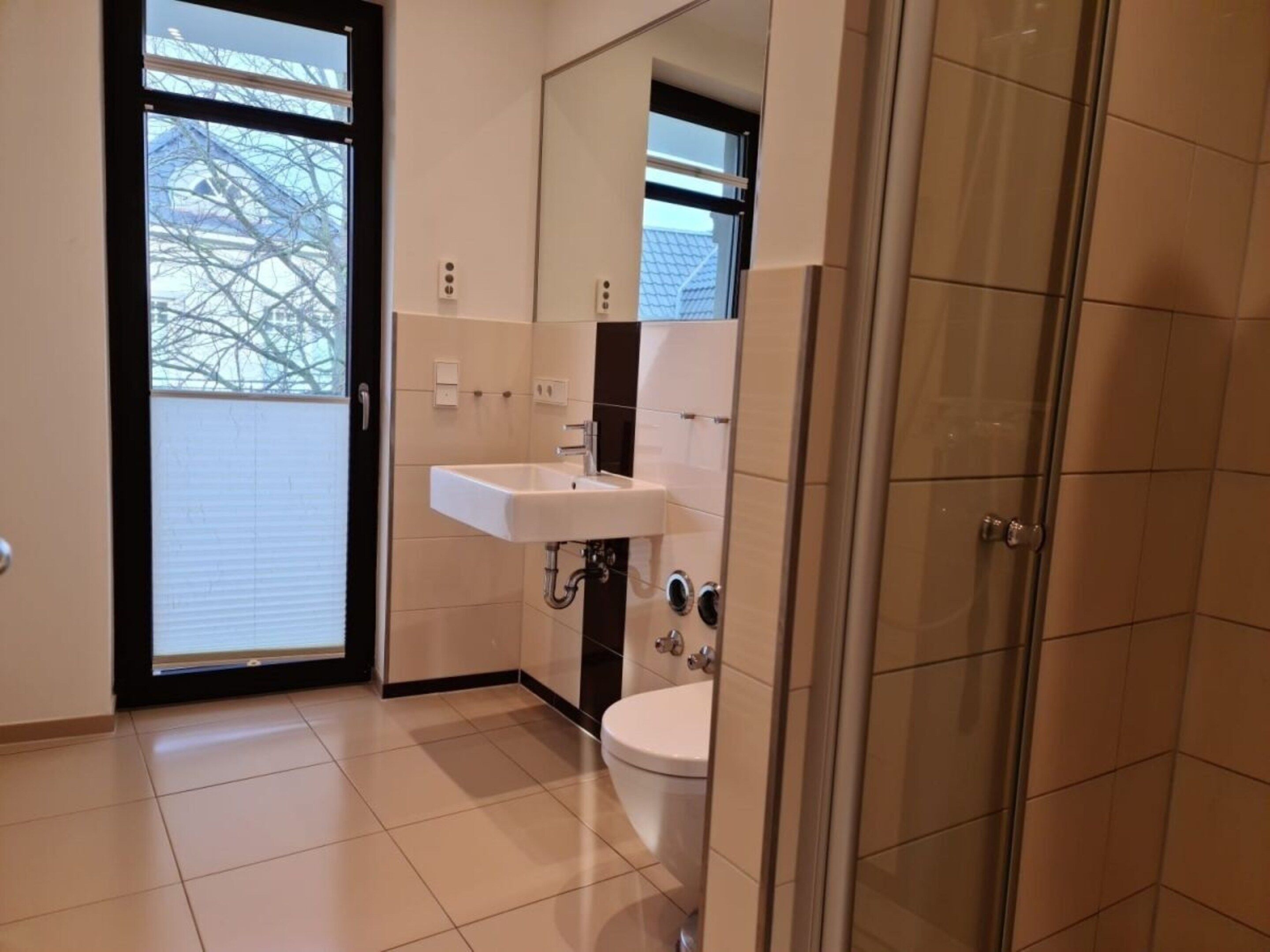 Une salle de bain moderne équipée de toilettes, d’un lavabo et d’une douche.
