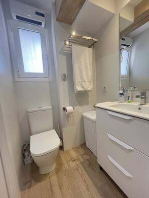 A small bathroom with a toilet, a sink, and a mirror. - New Listing (Benicasim)