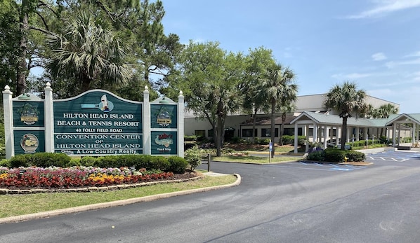 Bordje voor Hilton Head Island Beach & Tennis Resort, met logo van een golfbaan, restaurantlogo en een parkeerplaats.