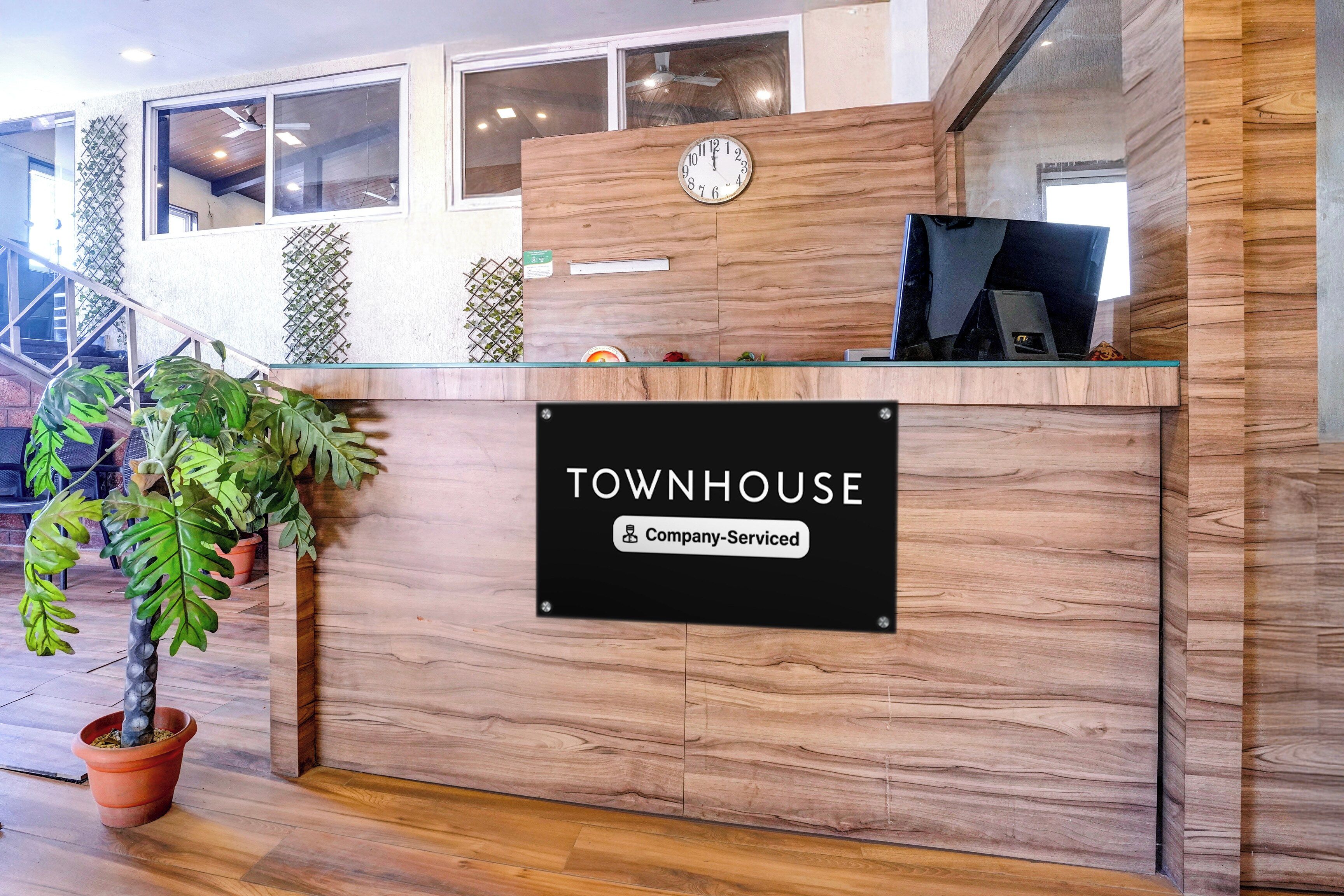 A reception desk with a sign reading 'TOWNHOUSE' and 'Company-Serviced.'