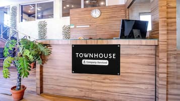 A reception desk with a sign reading 'TOWNHOUSE' and 'Company-Serviced.'