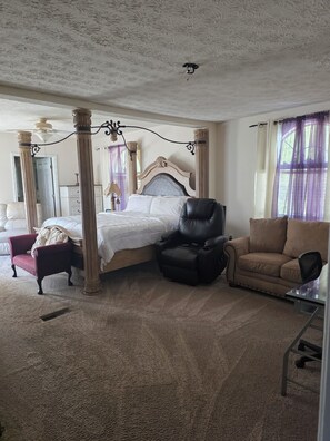 A bedroom with a four-poster bed, a chaise lounge, a leather armchair, and a sofa. - Wonderful 2-bedroom house with AC in Winterville (Winterville)