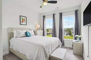 Una camera da letto con un letto, un comodino, una lampada e vista sull'esterno.