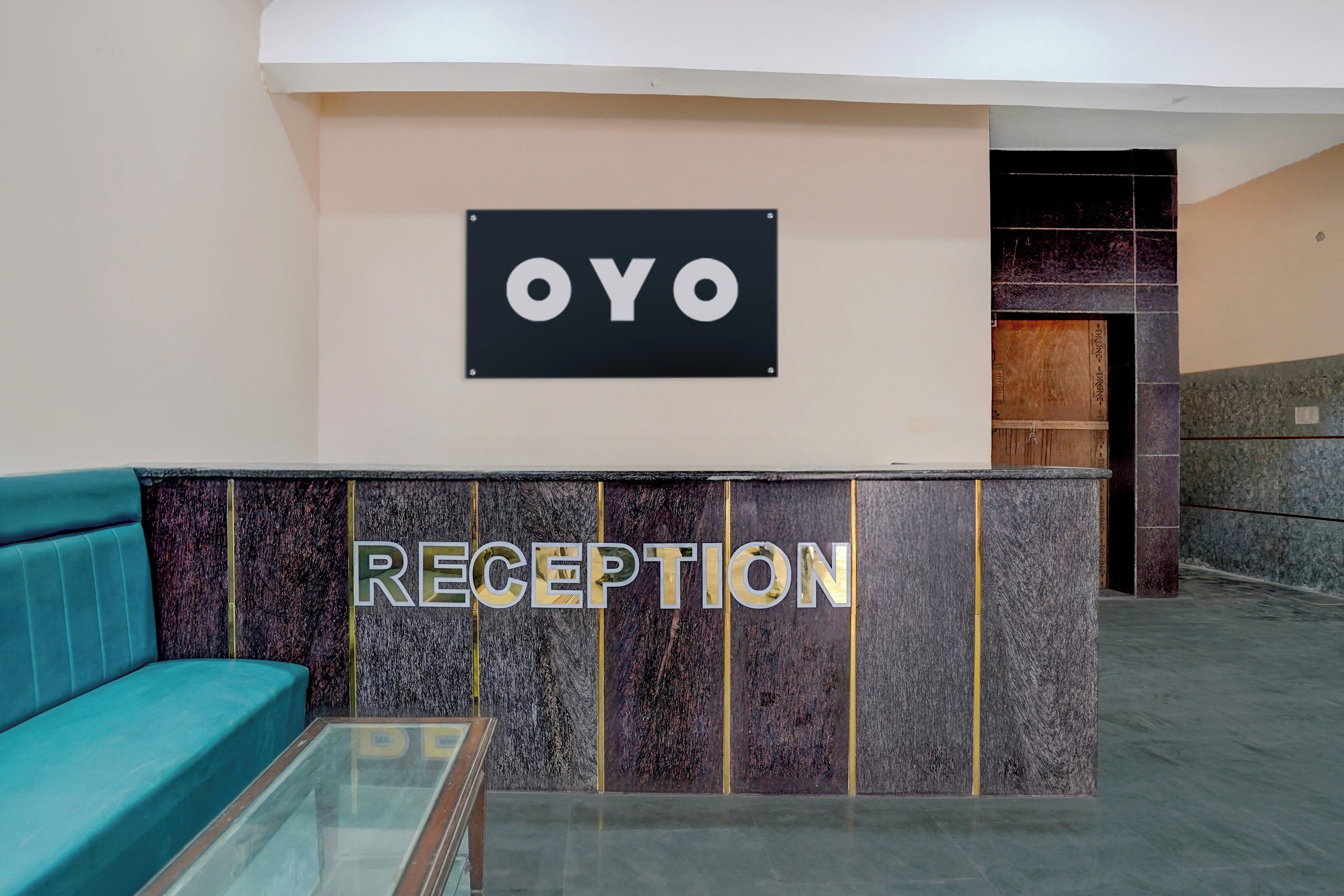 Un área de recepción con un letrero que dice 'OYO' y un mostrador de recepción.