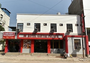 Un edificio de dos plantas con un letrero que dice 'Hotel Gatri Palace' y un restaurante llamado 'Anjana Restaurant' en la planta baja.