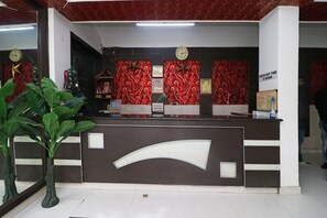 Una mesa de recepción con un reloj, una decoración de estrella y un cartel que indica la hora de salida.