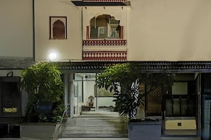 Un edificio con un estilo arquitectónico tradicional, que presenta un arco central y una escalera que conduce a una entrada.