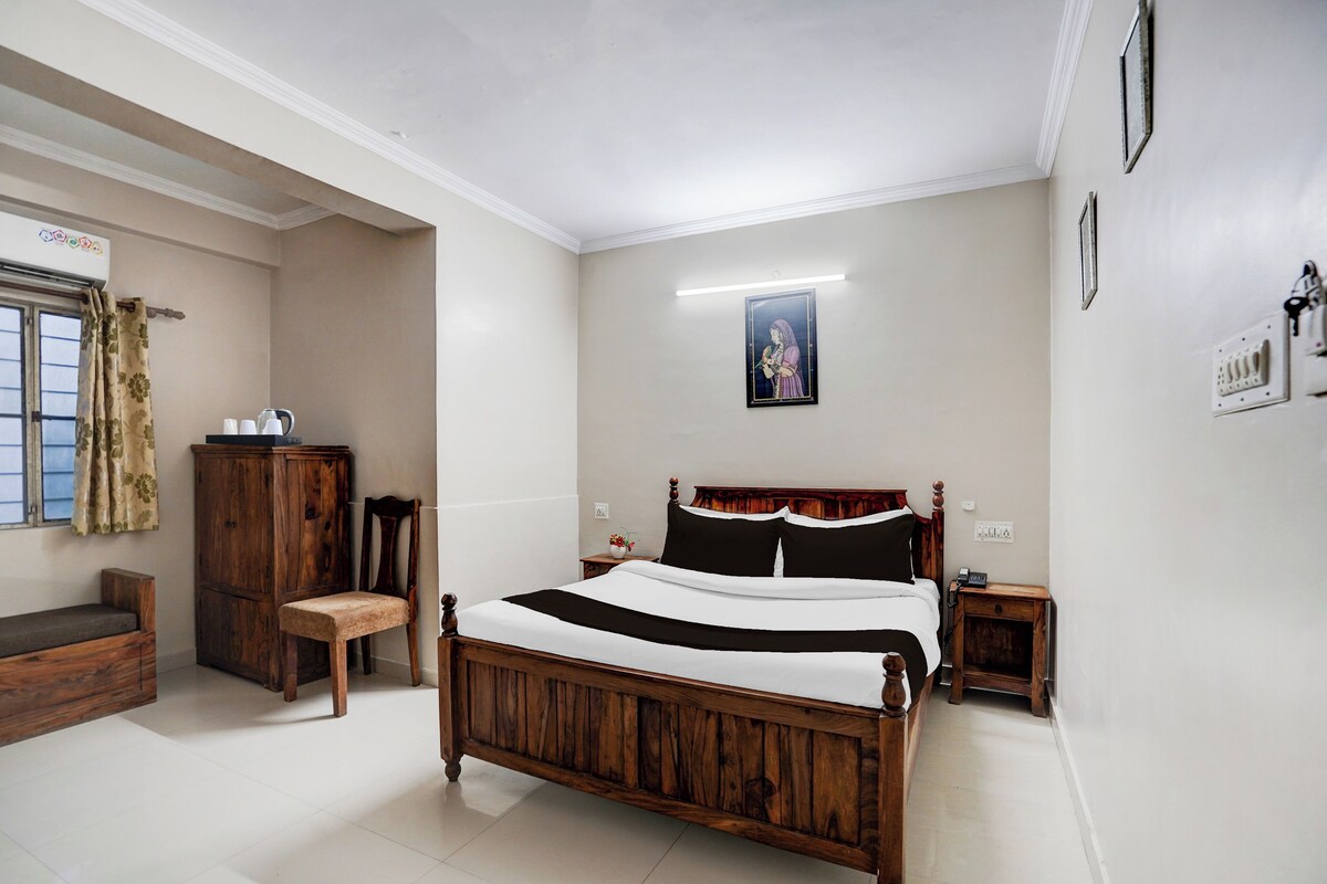 Un dormitorio con una cama de madera, una mesita de noche, una silla, un armario y una ventana con cortinas.